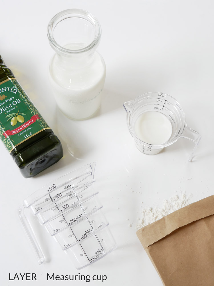 YAMAZAKI製【LAYER】段々計量カップ、トライタン樹脂の200mlと500mlサイズが液体を計量している様子