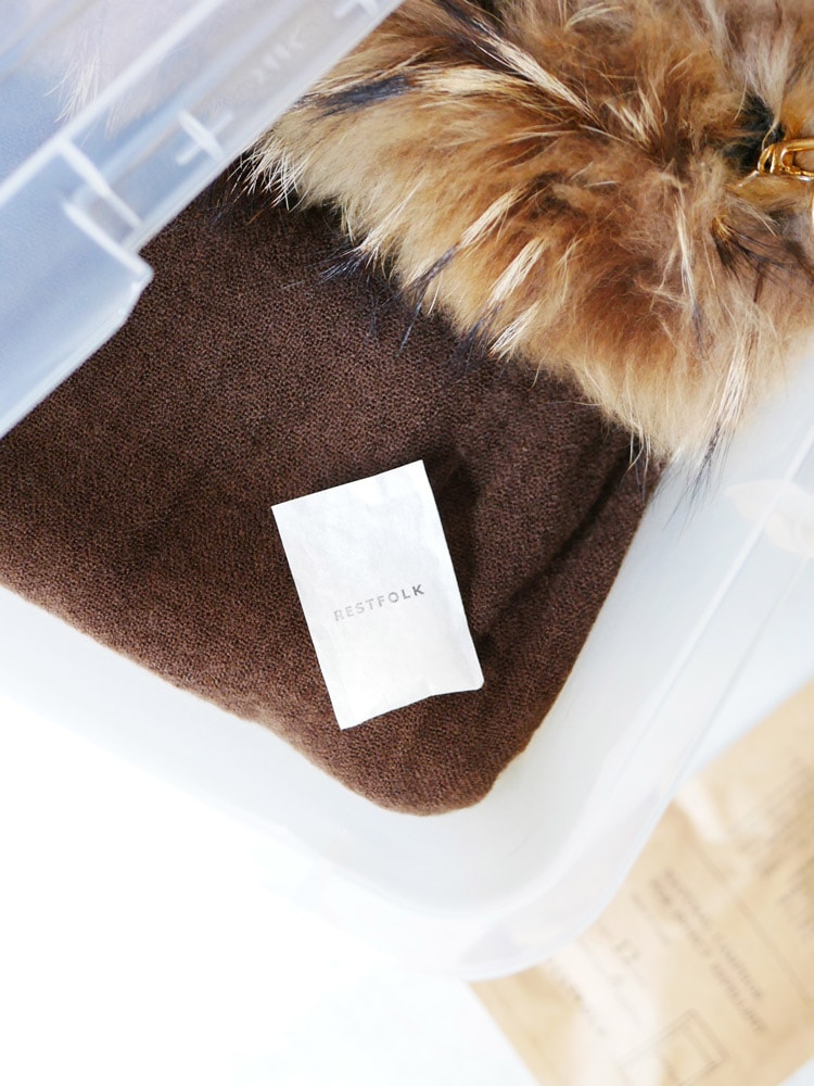 ブラウンのスエードパーカーやレザーバッグと共にREST FOLKのくすのき天然精油カンフルオイルが配置された写真