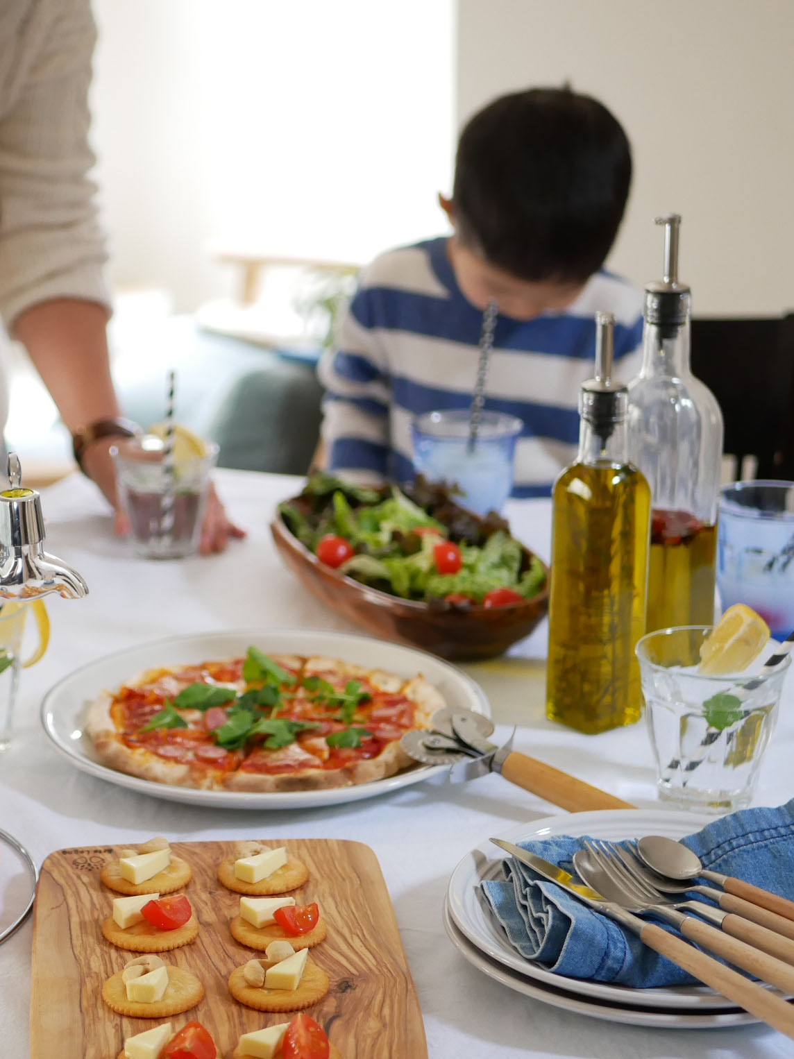 SALUSカプリオイル&ビネガージャーのガラス製ボトル、ステンレスとシリコーンゴムのパーツが食材とともにキッチンテーブルに配置されている