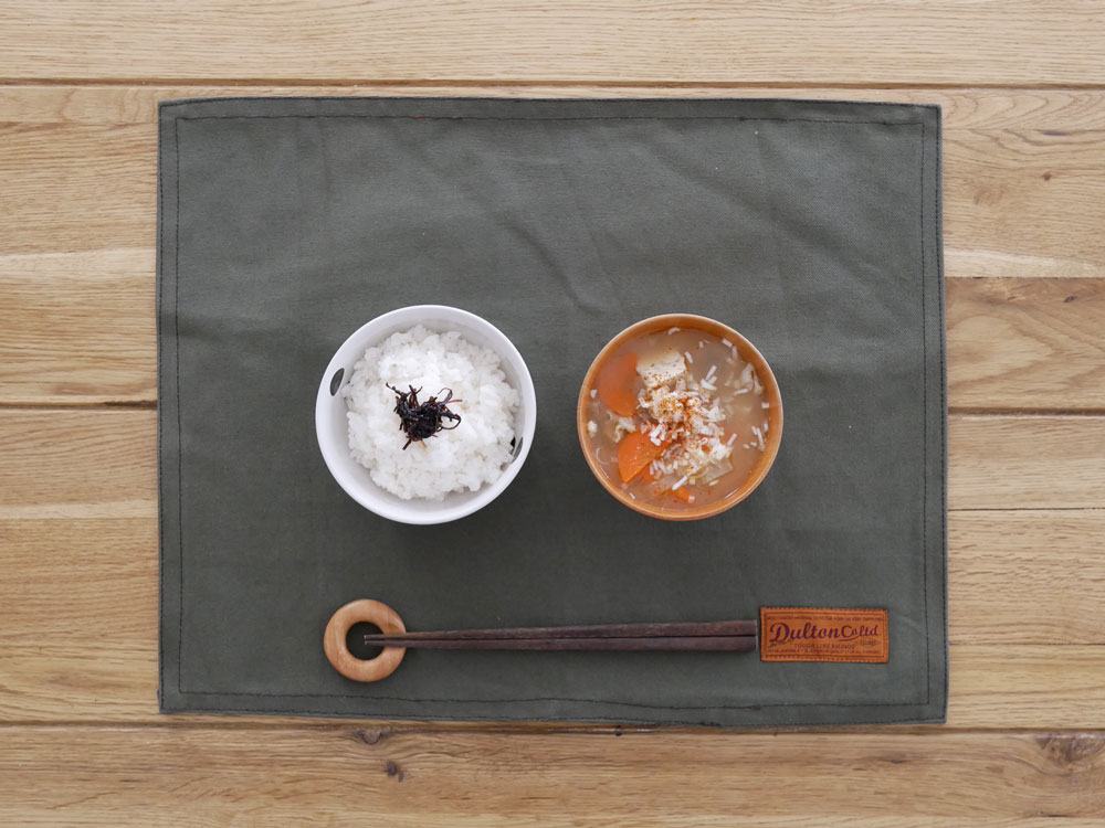 カーキ色のダルトン製コットンプレイスマットがテーブルに敷かれています