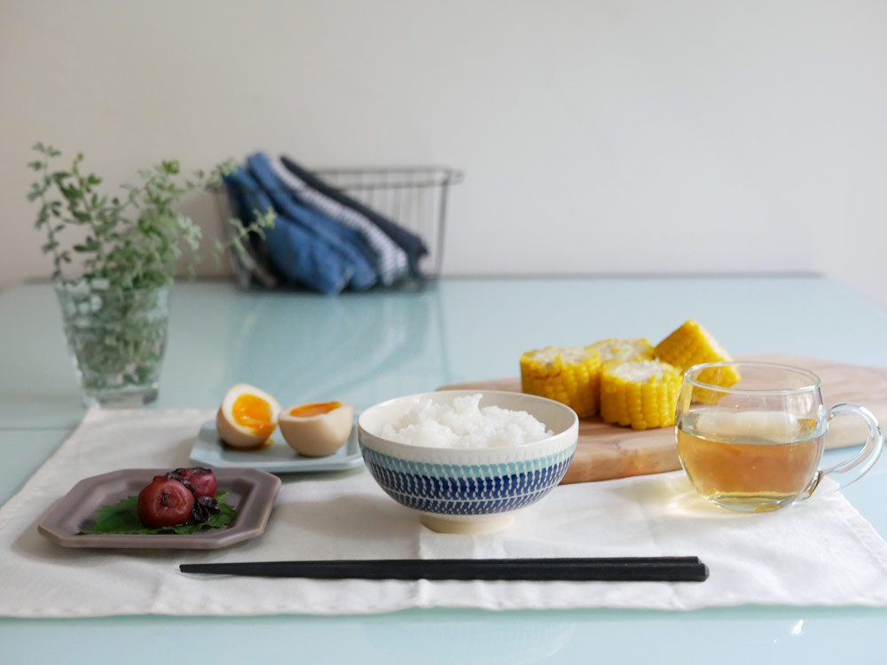 栞ブランドの白い土製ライスボウルがテーブルに美しく配置されている