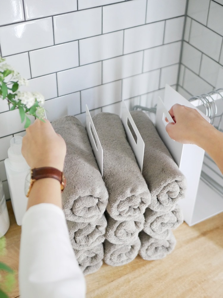 towerブランドの連結タオル収納ラックにタオルが掛かっている