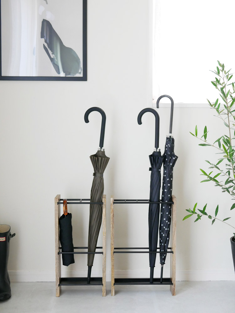 アイアンとマンゴーウッド製の傘立てに衣類ハンガーが掛かっている