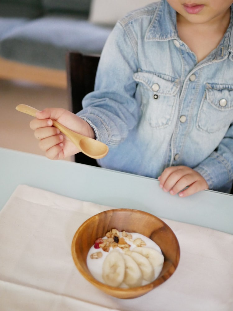 SALUSの天然木白木カトラリーセット。コーヒースプーン130mmとデザートフォーク175mmを子供が手に持っている様子