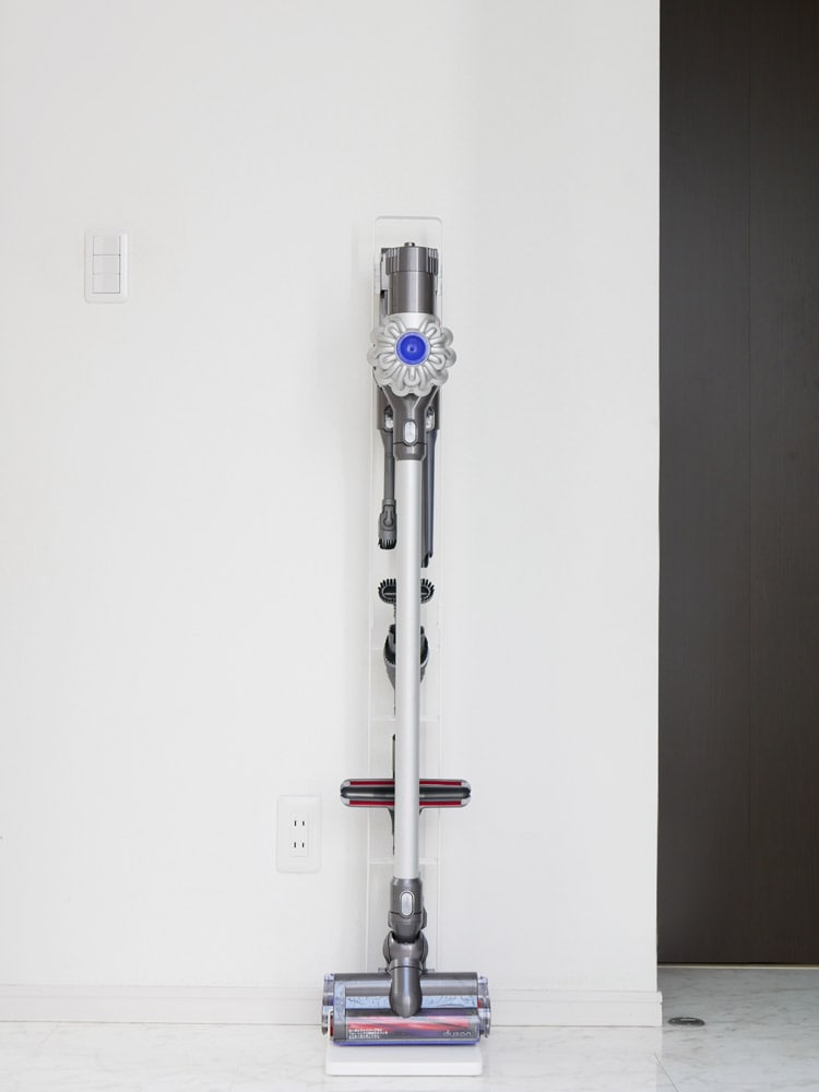 ダイソンコードレスクリーナー【tower/タワー】スタンド。銀色のアルミ製スタンドが木製フローリングの上に設置されている