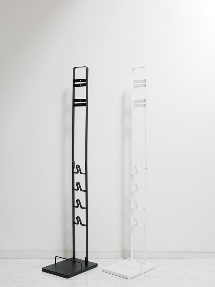 タワー製コードレスクリーナースタンドが壁に取り付けられ、ダイソンVシリーズ対応クリーナーを収納している様子