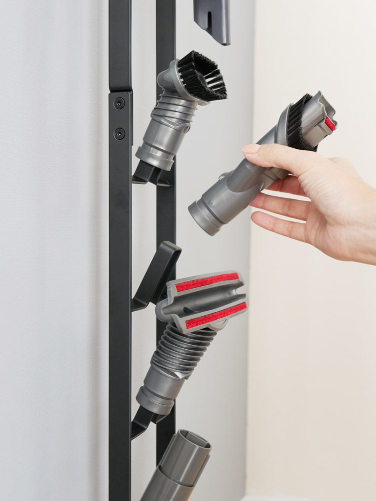 towerブランドのコードレスクリーナースタンドにダイソン製コードレスハンディークリーナーを収納している様子