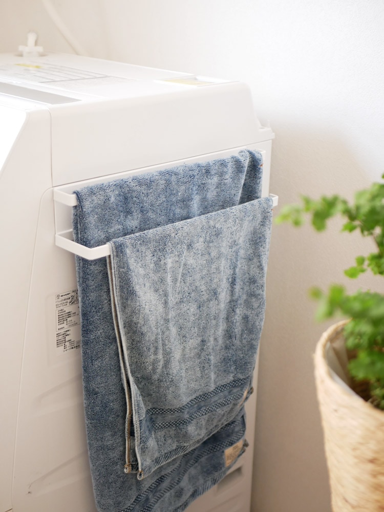 タワー製の2段マグネットタオルハンガーが洗濯機の横に設置され、タオルを掛けている様子