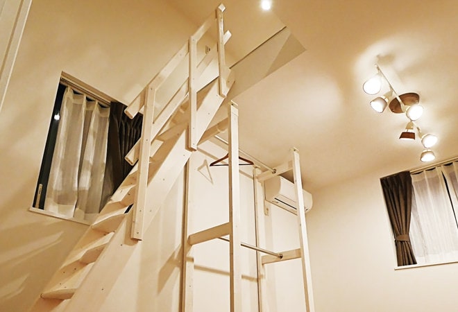 洋室のフリースペースに掛かる、塗装した木製ロフト階段・デザインステップのお部屋実例。