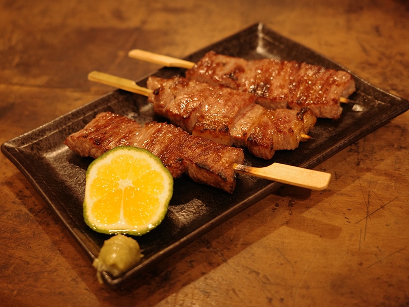 焼いた肉に花良治みかんを添えた料理