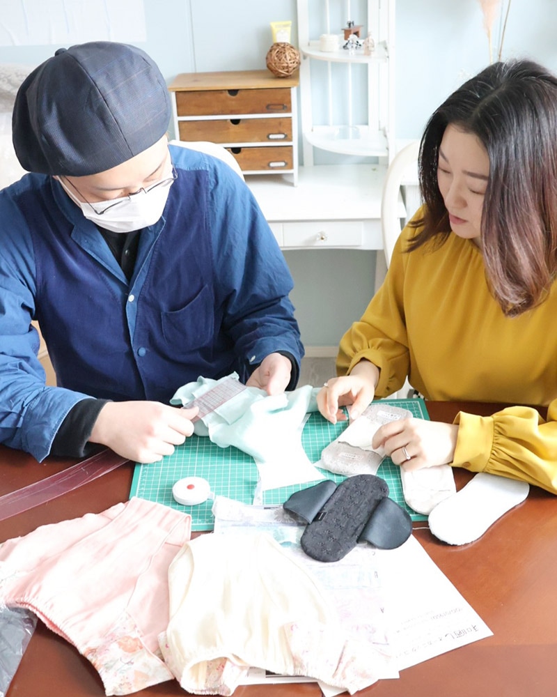 布ナプキンとふんどしパンツの試作品を確認する商品開発担当者