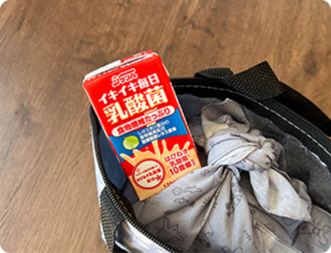お弁当と一緒にイキイキ毎日乳酸菌を持っていく様子