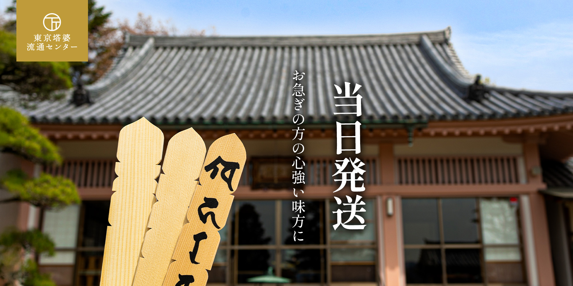 東京塔婆流通センターの墨書きされた卒塔婆、背景に寺院が写っている。当日発送でお急ぎの方の味方に。