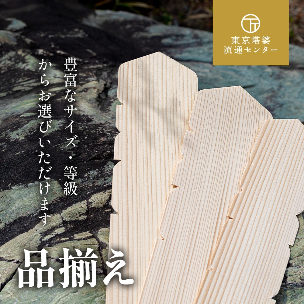 東京塔婆流通センターの卒塔婆、卒塔婆の背景に自然岩と植栽が写っている。豊富なサイズや等級をお選びいただけます。