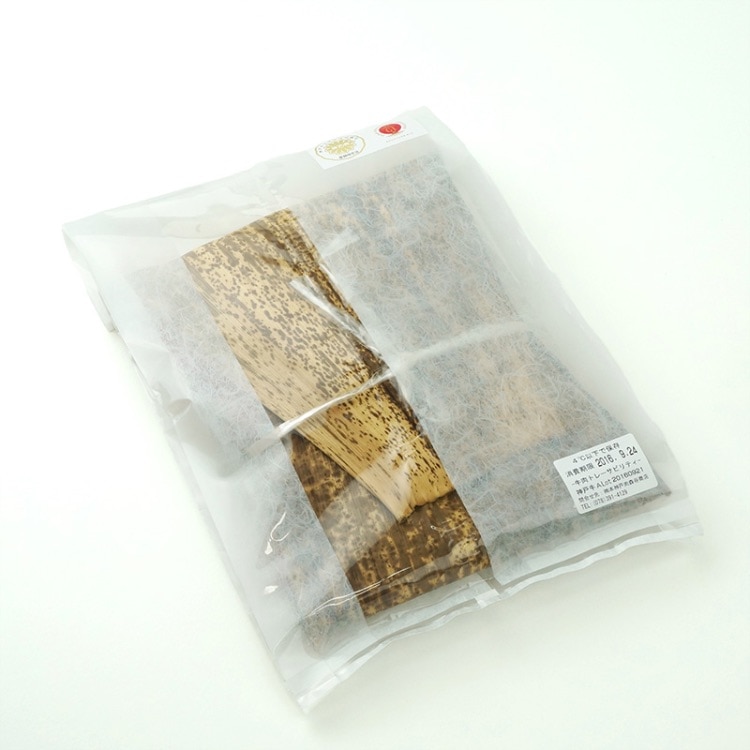 肉を竹の皮に包んで和紙調袋に入れる