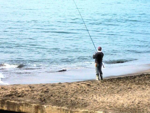 岸で釣りを楽しむ一人の男性