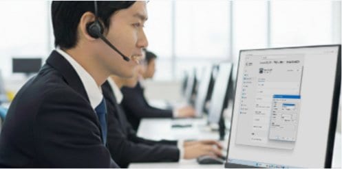 ヘッドセットを着けてパソコンで初期設定データを入力するサポートスタッフ