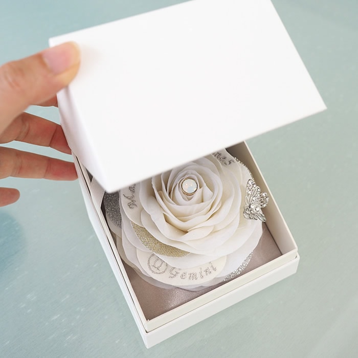 箱を開けると現れる大輪の白いバラ、彼女も思わず笑顔に