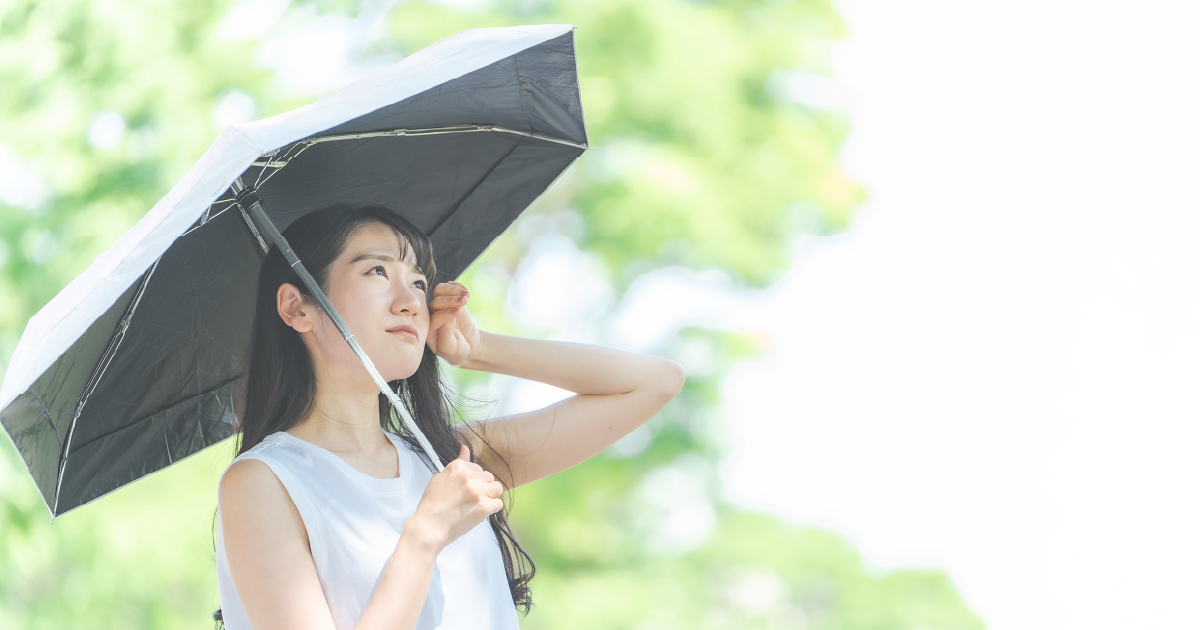 夏の日差しと日傘の女性