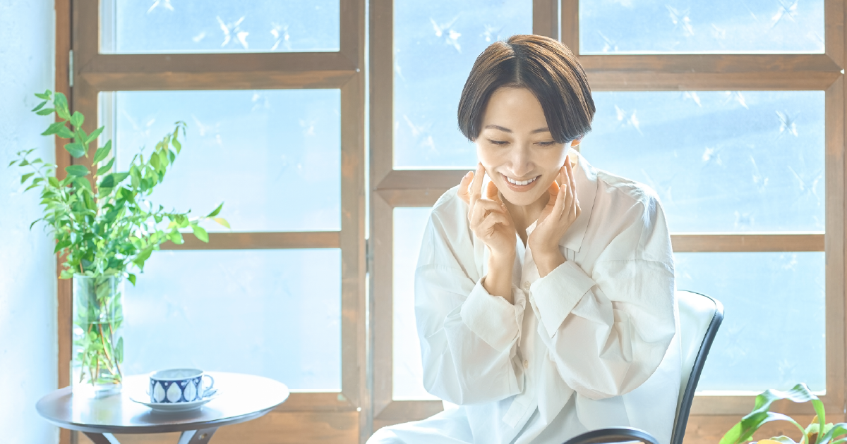 鏡を見てほほ笑む女性