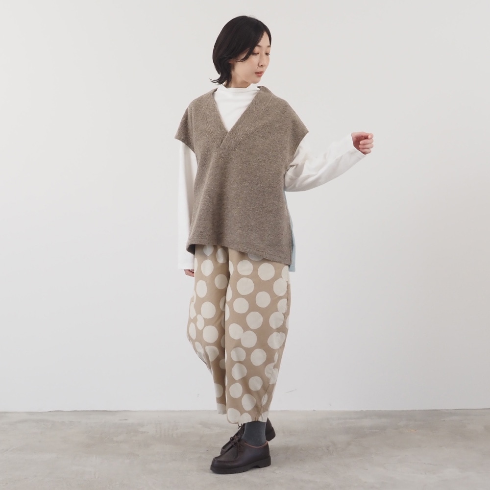 トラベルウールプレミア バイカラーベスト　ベストを着た女性の全身