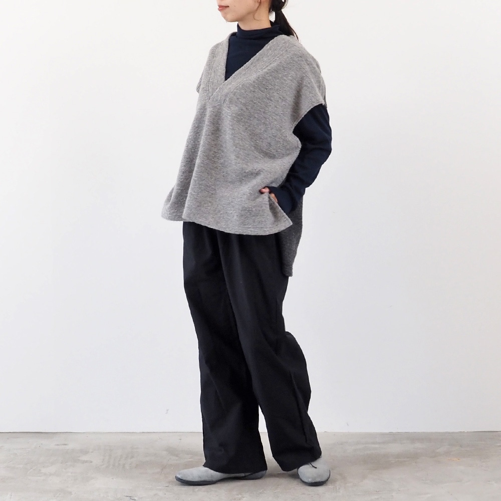 トラベルウールプレミア バイカラーベスト　ベストを着た女性の全身