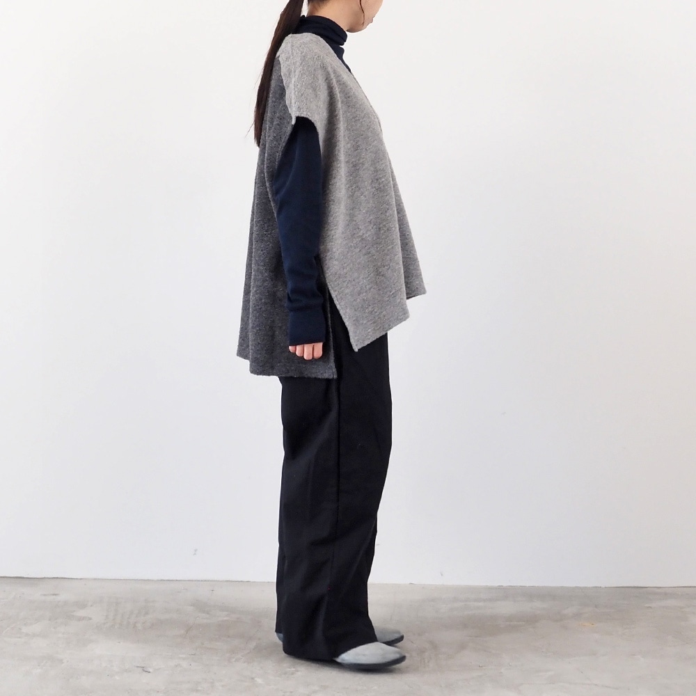 トラベルウールプレミア バイカラーベスト　ベストを着た女性の全身