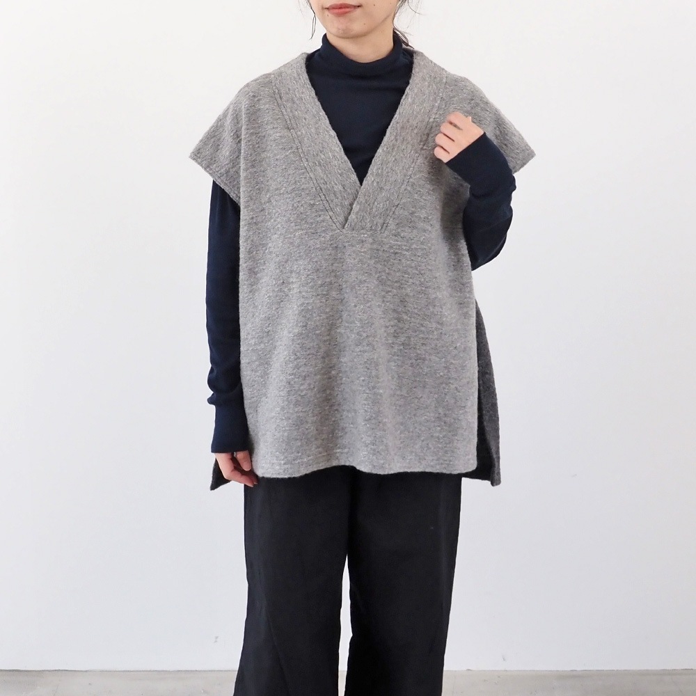 トラベルウールプレミア バイカラーベスト　ベストを着た女性の全身