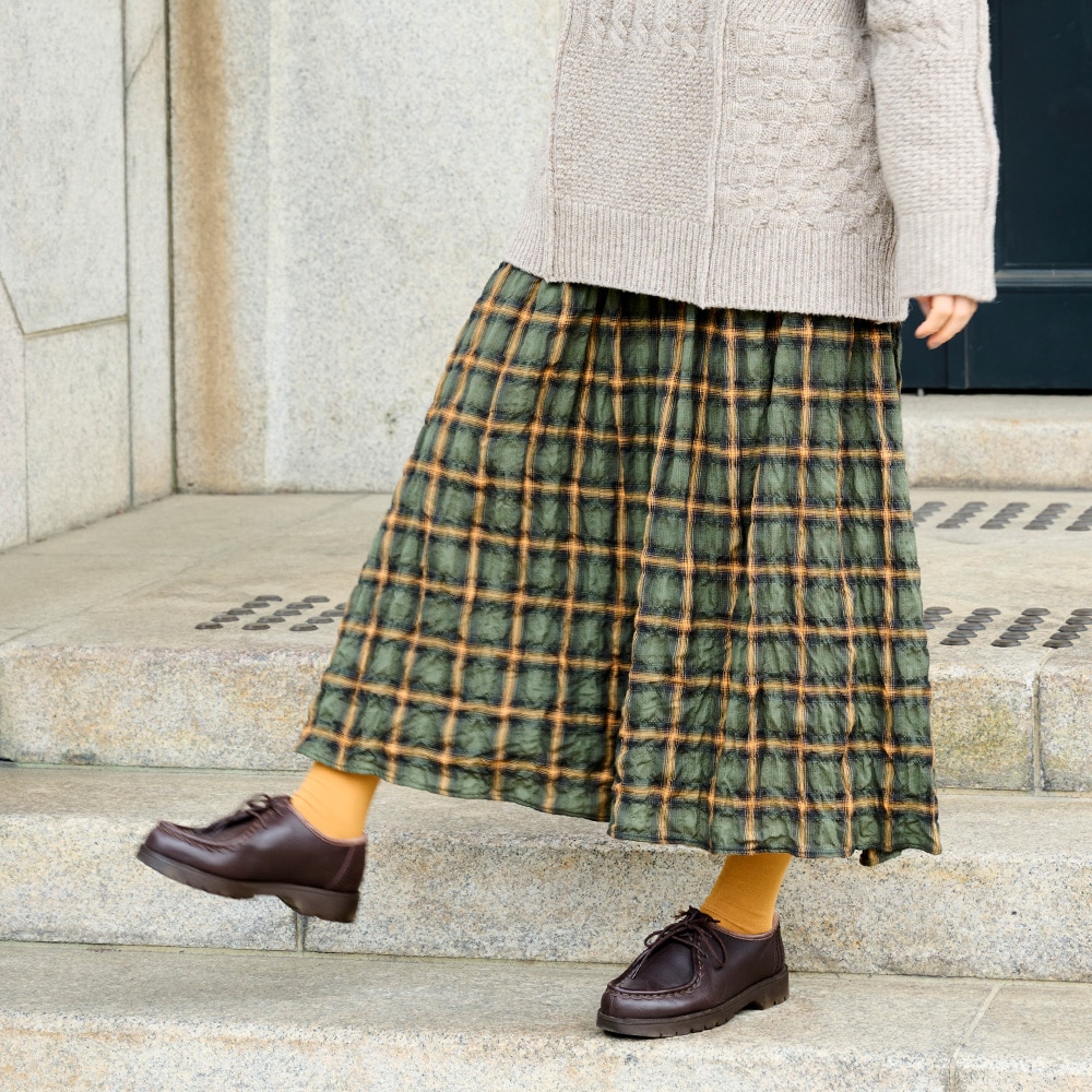 へリンボンシャーリングチェック スカート スカートを着た女性の正面