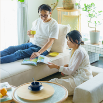 ソファで読書とくつろぎを楽しむ2人の写真