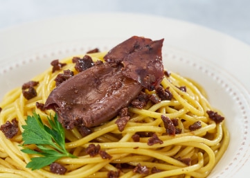 大きなイカの身と、細かく刻んでこんがり炒めた肉をトッピングした、濃厚なソースのスパゲッティ