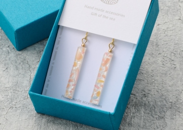 ジュエリーボックスに収められた、金色の金具とマーブル模様の装飾が施された、上品なハンドメイドアクセサリー