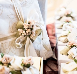 淡いベージュの布やリボン、造花で華やかにラッピングされたギフトボックスの山。