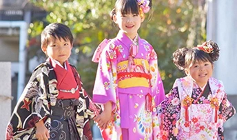 七五三の着物を着て並ぶ、笑顔の男の子と二人の女の子
