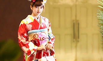赤い振袖を着て正面を向いている、華やかな着物の女性
