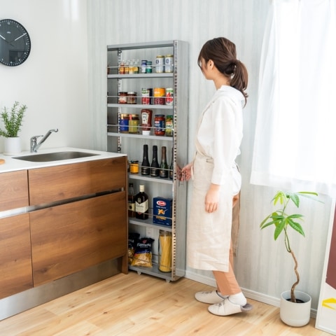 収納に手を伸ばす女性