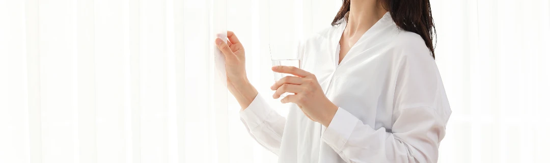 女性がコップの水を飲んでいる様子