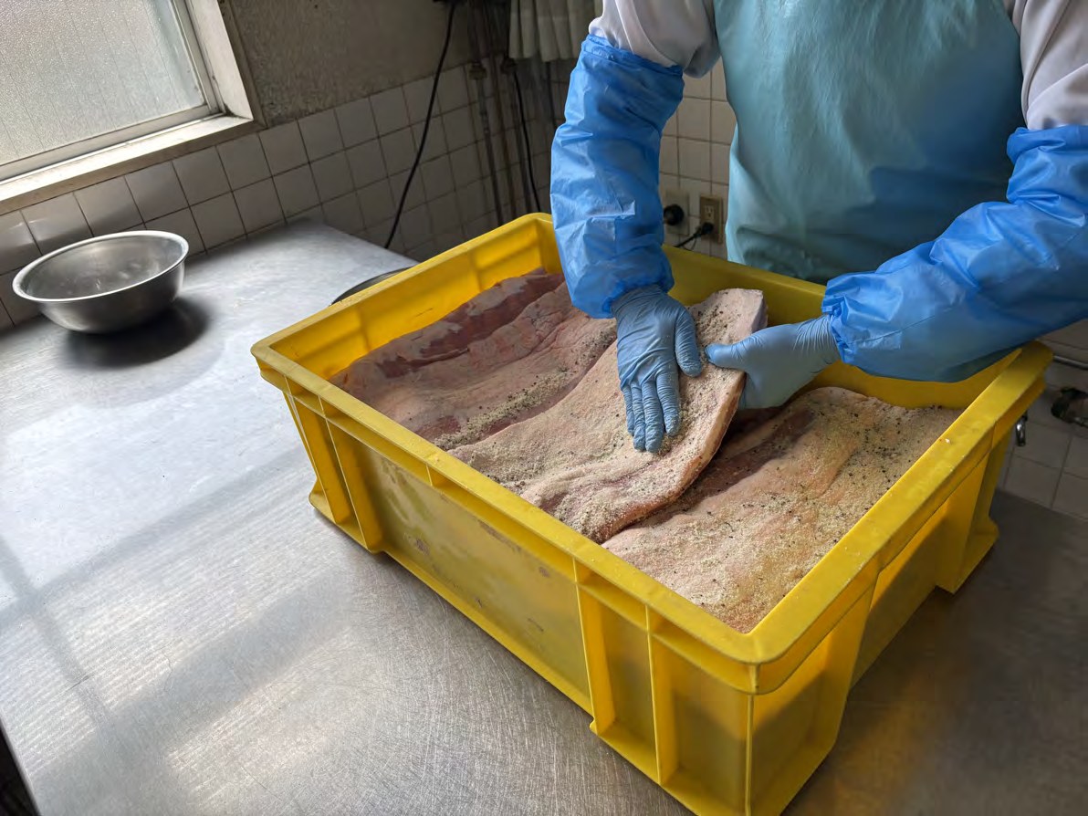 地元契約農家の国産豚肉を手作業で仕込む様子