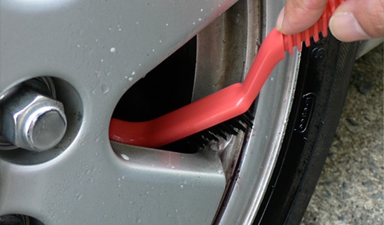 タイヤとホイールを念入りに：ホイールをブラシでこするアップの写真