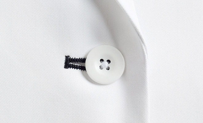 第一ボタンホールのダークネイビーが光るデザイン