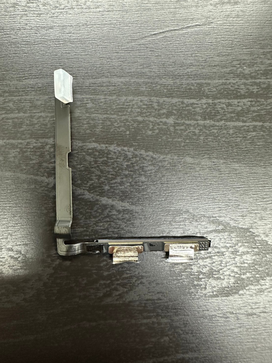 切り離したiPhone純正バッテリーのケーブル部分。BMS基板、フレキシブルケーブル、金属ブラケット、コネクタ保護カバーが揃った状態